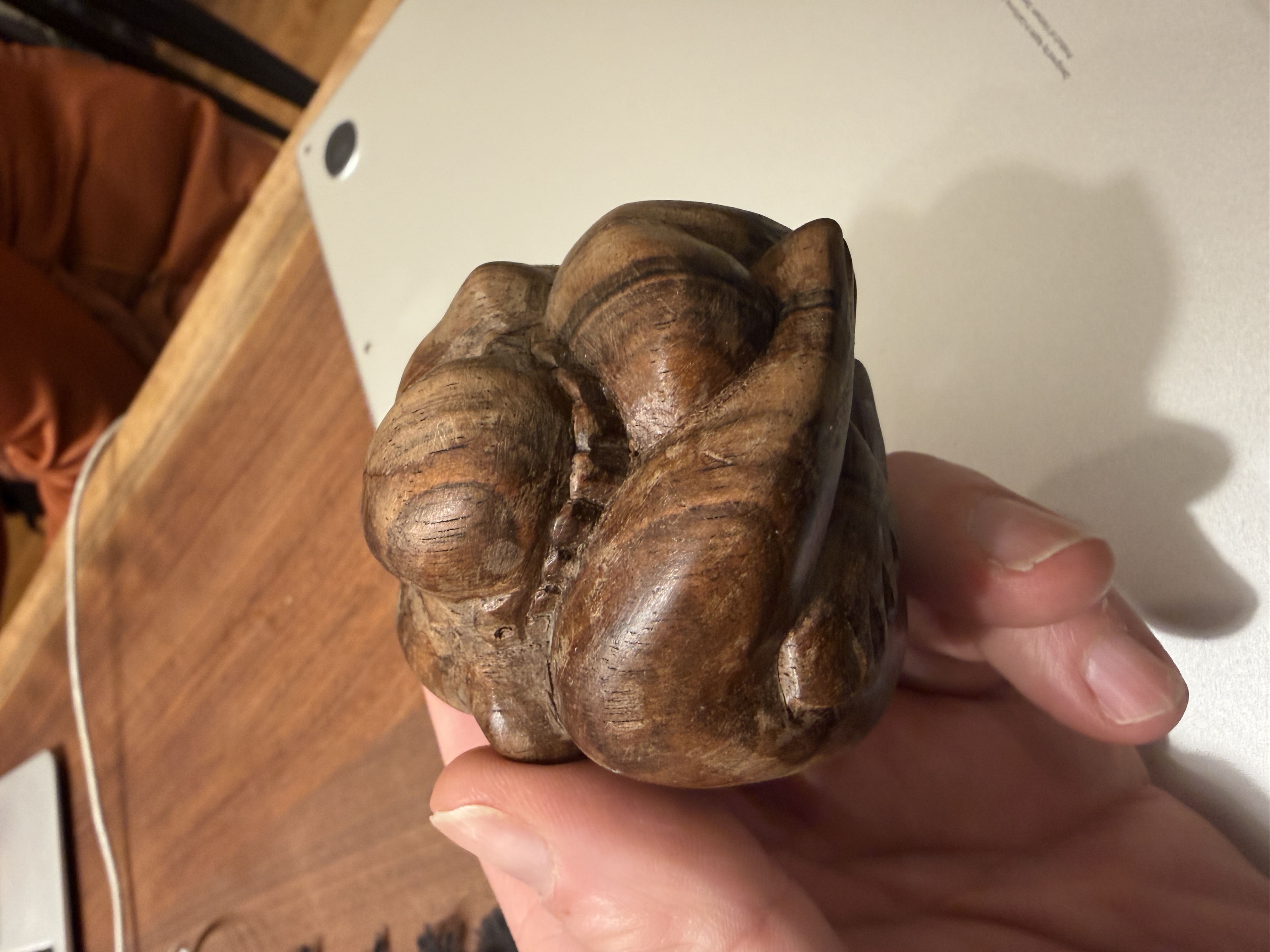Hand-carved wooden figure in the head-between-knees posture described in the Hekhalot literature — the body folded into a single compact mass